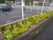 駐車場を囲むように設置されている白いフェンスの前には、石造りの花壇が造られている。花壇にはさまざまな種類の草花が、色とりどりに咲いている。