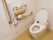 洋式タイプの便座が備え付けられたトイレである。縦横型の手すりが設置されているほか、ナースコールも完備されている。