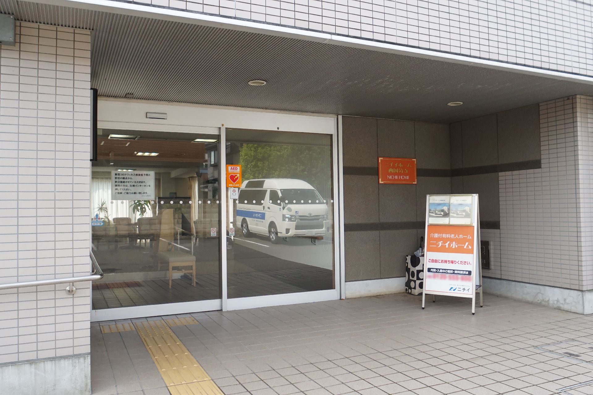 看板が設置され、段差が極力排除された介護施設の外観