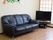 足を伸ばせる黒い大きなソファーと薄型テレビが部屋に置かれている。壁には、スタッフお手製の装飾物が飾られている。