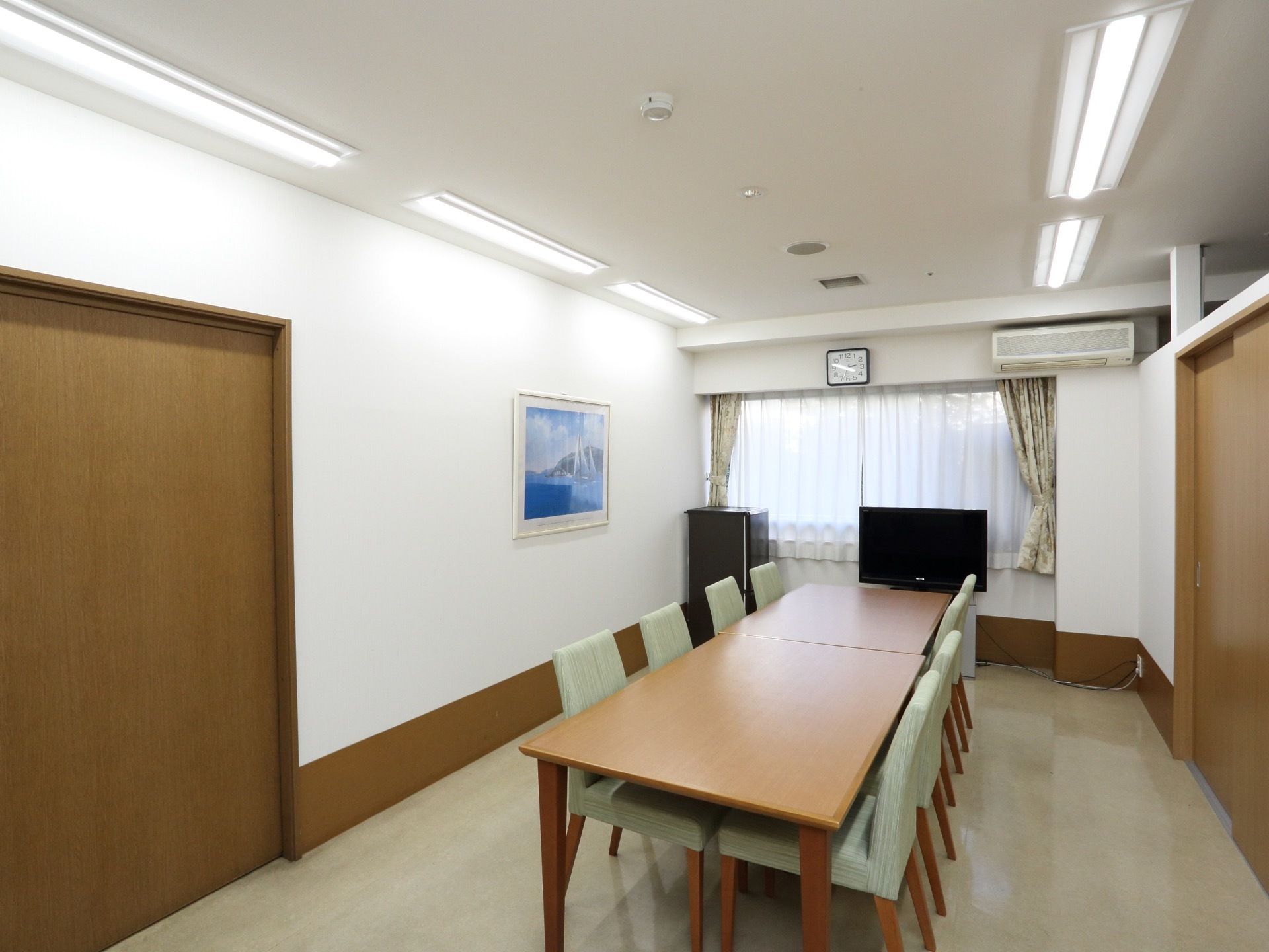 休憩室は個室でテレビが置かれている。机が横並びに2台あり、明るい緑色の椅子が8脚ある。少人数でも大人数でも利用できる。