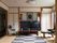 和風の畳の部屋に、大型テレビと大きな座卓、ひじ掛け付きの椅子などが置かれている。壁にはエアコンが備え付けられている。
