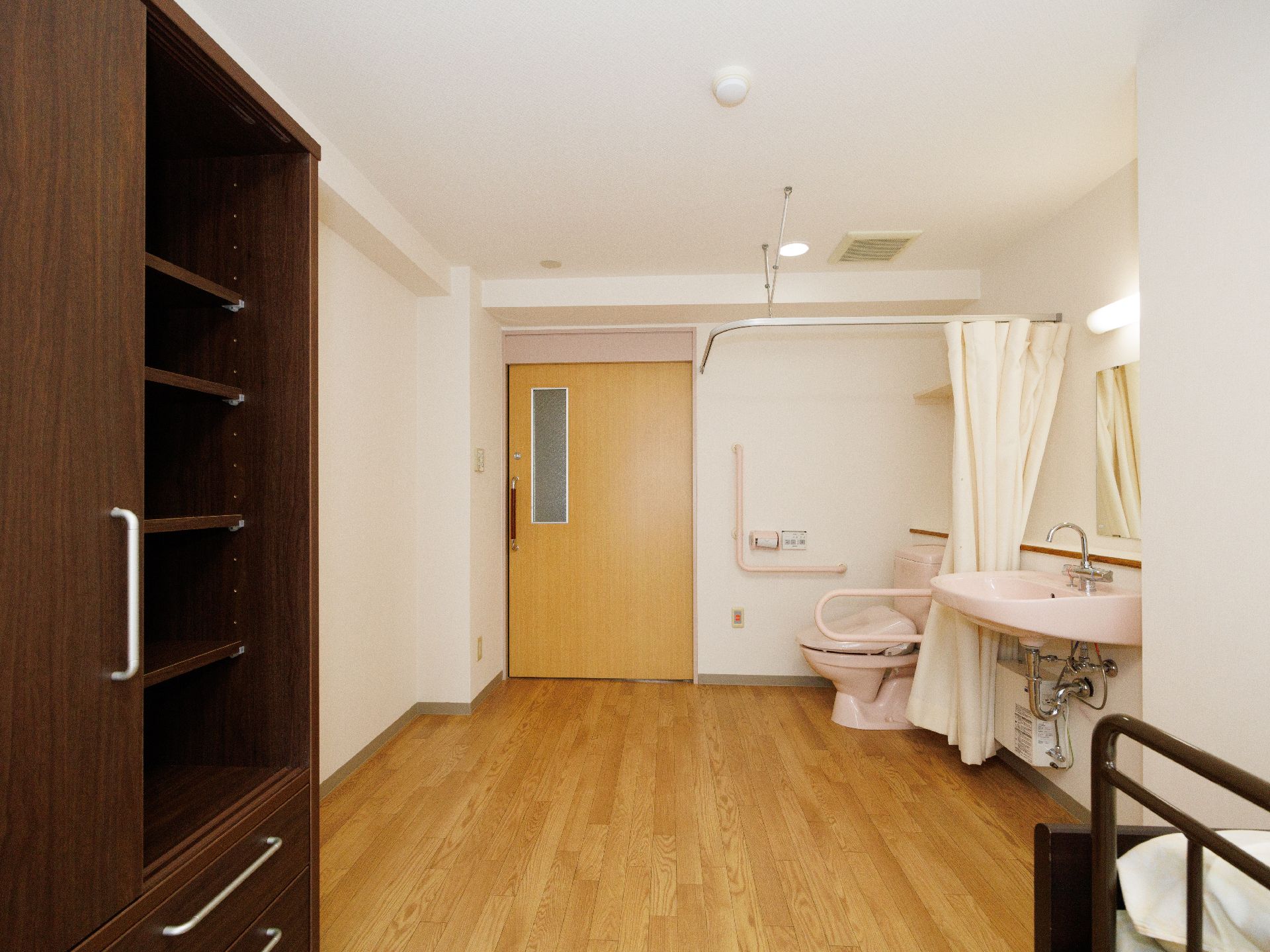 トイレと洗面台と棚が置かれた白い壁の部屋