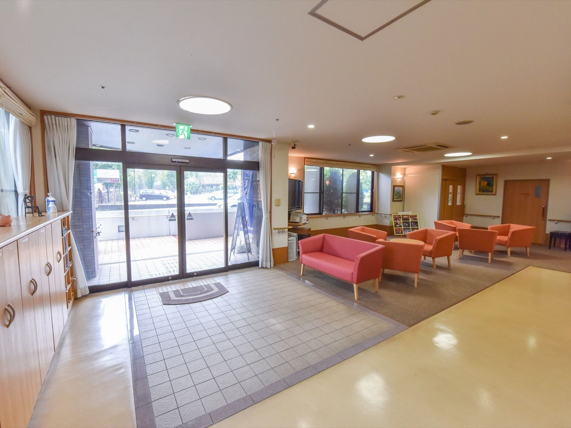 車椅子利用者様や足腰が悪い入居者様でも使いやすいよう、段差のない玄関である。ソファが置いてあるので腰かけて靴の着脱ができる。
