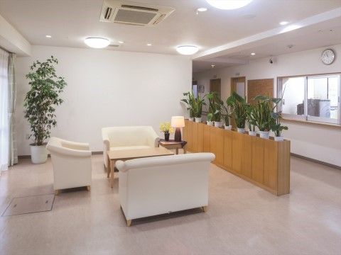 「ニチイホーム 元住吉」のエントランスホール。ソファの配置された談話スペースがある。