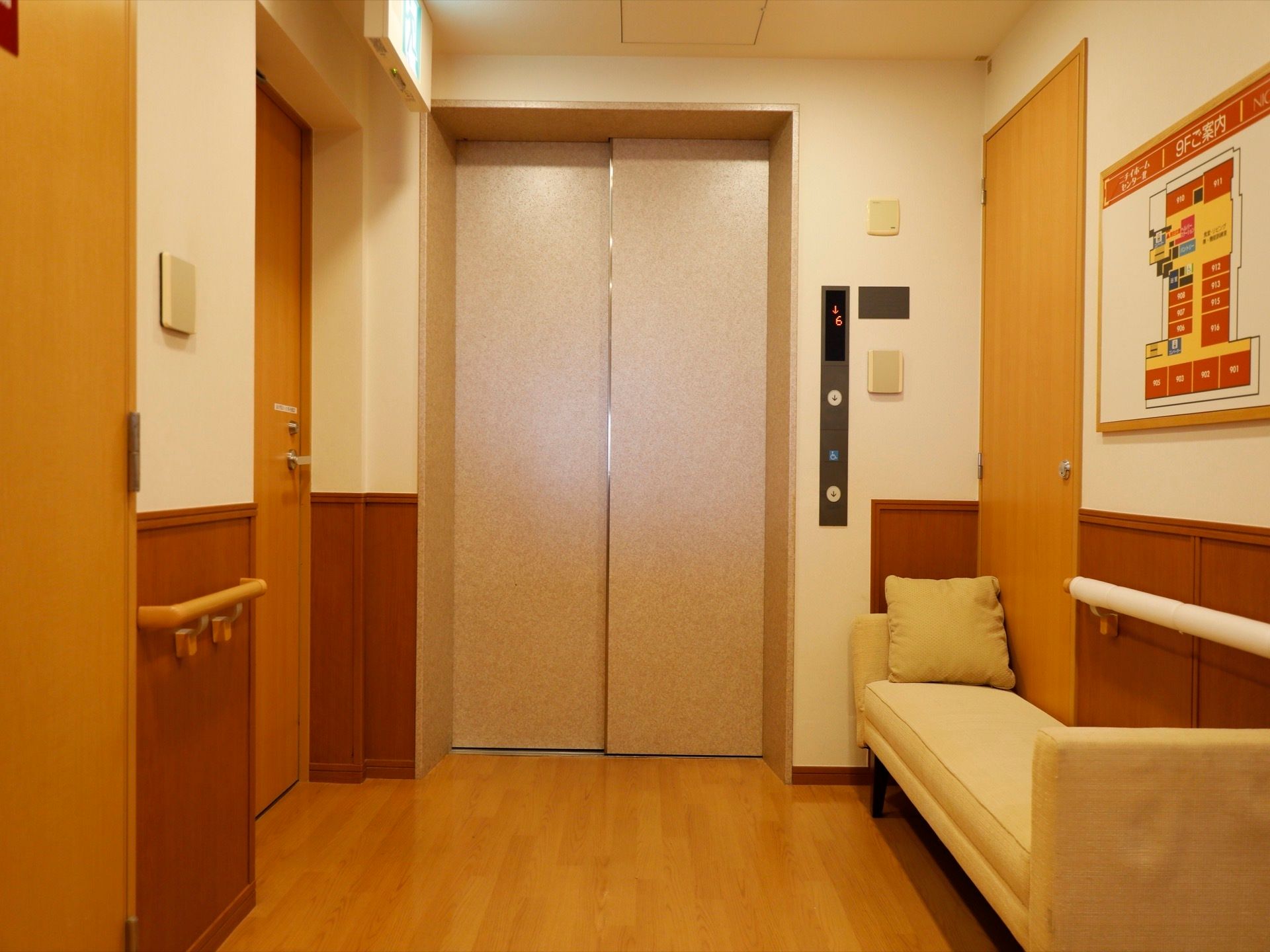 間口の広いエレベーターになっており、その右手に非常口がある。壁側にソファが置かれており、その上にはフロアマップが掛けられている。