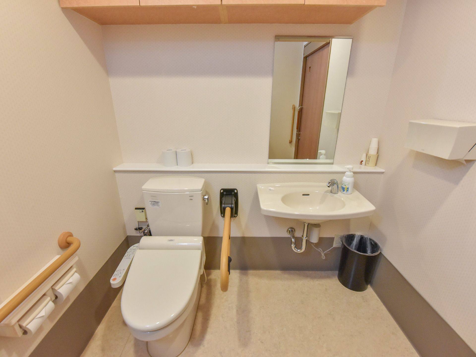 白で統一された明るいトイレには手洗いスペースも完備されている。立ち上がりや座る時に便利なレバー付いている。ペーパータオルも完備。