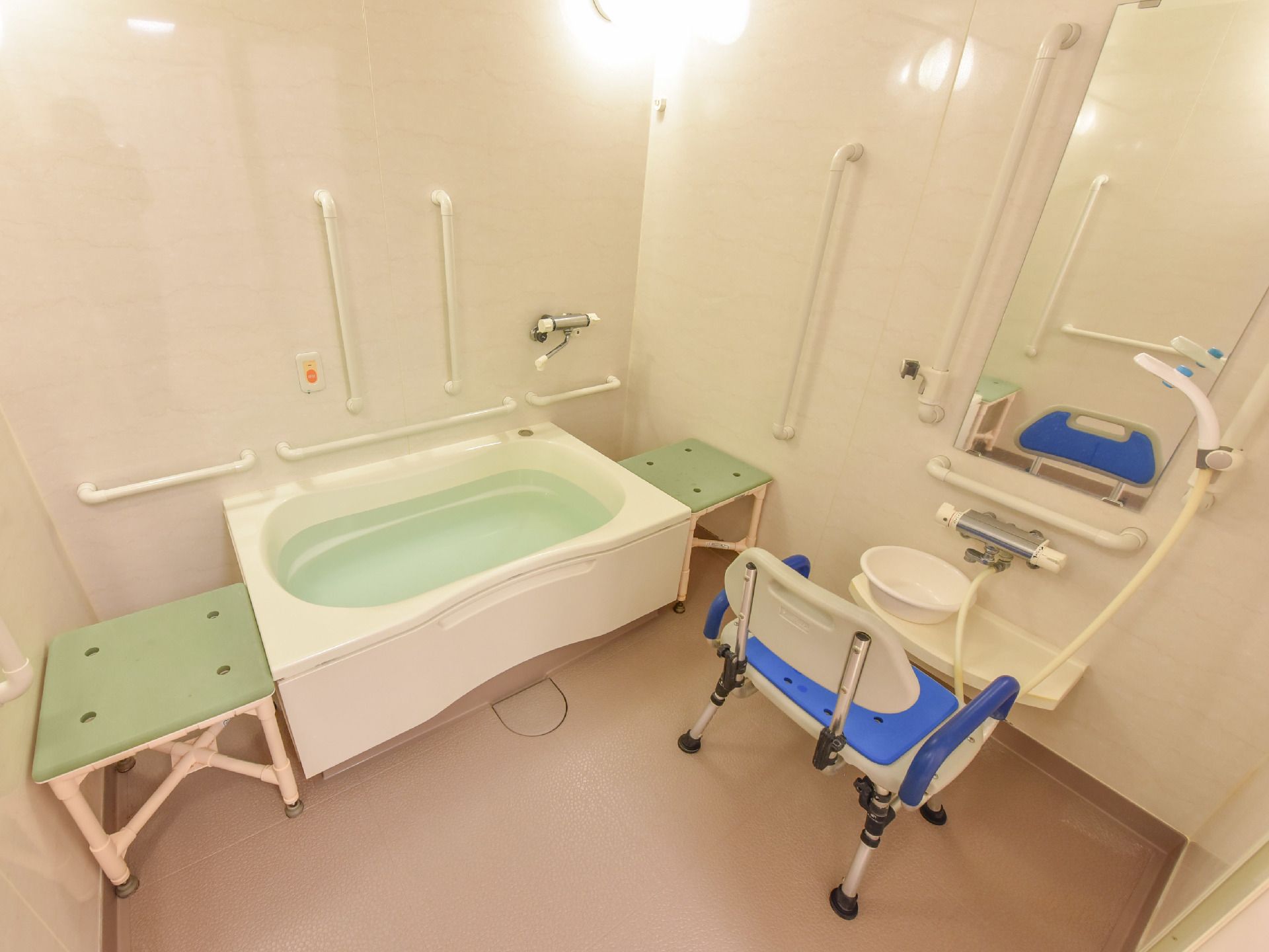 白が基調の清潔感のある浴室には、手すりや介護用の椅子、非常用呼び出しブザーが完備されていて1人でも安心して快適に入浴ができる。