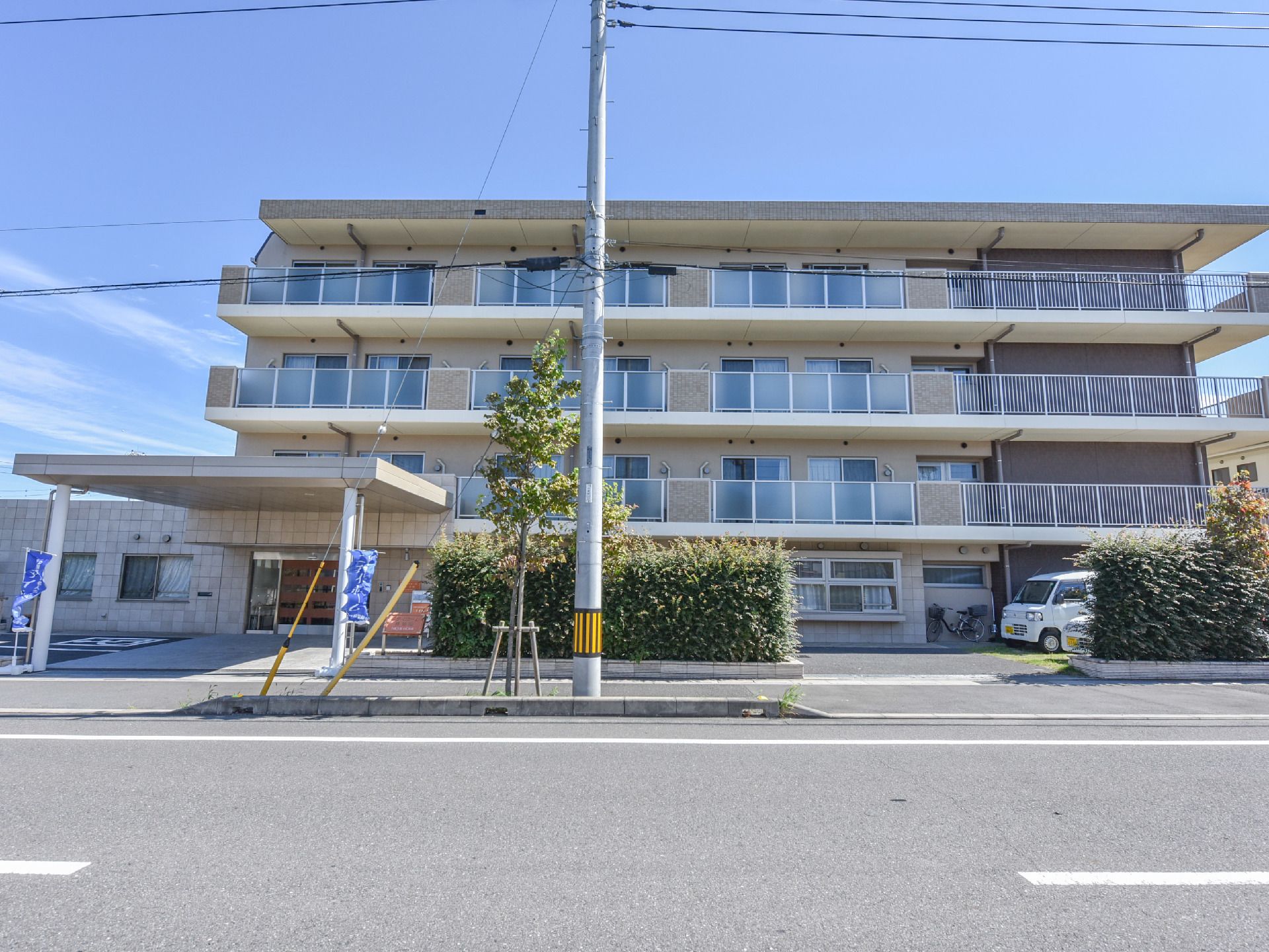 4階建ての大きな建物。エントランスの屋根は広いので、雨の日の移動でも濡れる心配がない。また、駐車場は建物のすぐそばにあり便利。