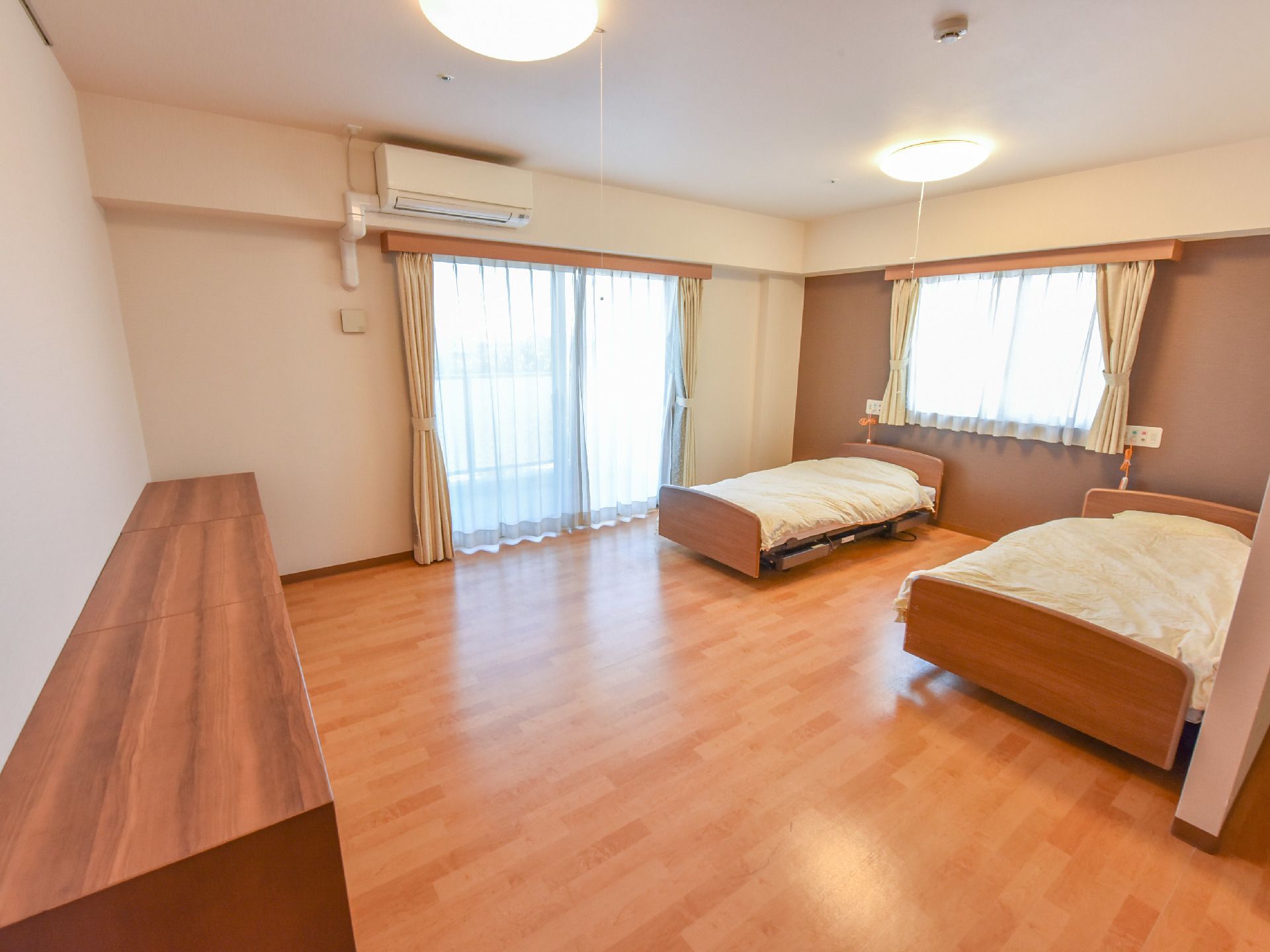 夫婦同居型の居室はゆったりとした空間に介護用ベッドが2台完備されている。角部屋なのでまどが2ヶ所あり明るい。