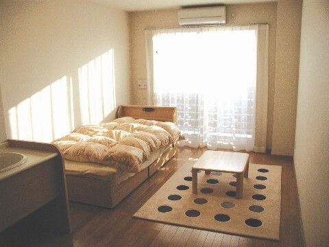 大きな掃き出し窓からやわらかな光が差し込む明るいフローリングの居室である。カーペットを敷いたり、お気に入りの家具を配置したりできる。