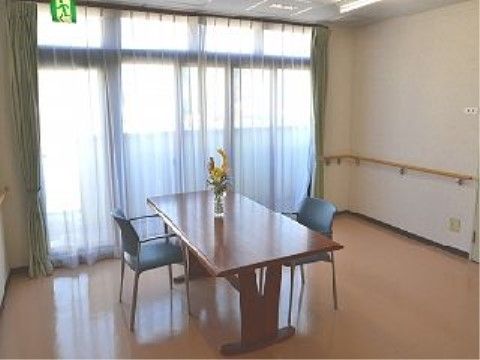 部屋の角には、カーブした手すりが設置してある。非常口でもある窓際には、テーブルと２脚の椅子を配置している。