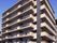 マンションのような外観の施設は7階建てである。施設の横の道路には、安全に通行できるように白線でとまれと書かれている。