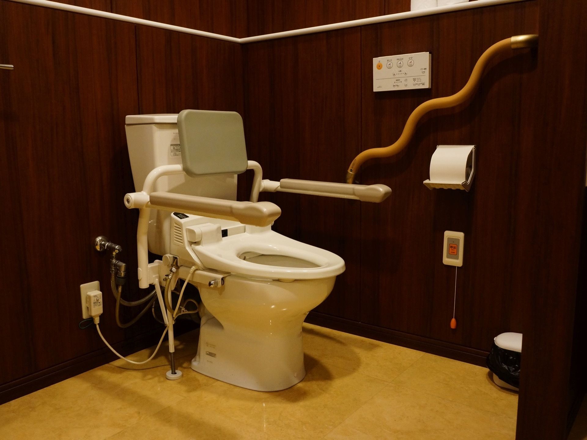 清潔感のあるトイレの壁は焦げ茶色で、床は大理石模様のベーシュ色になっており、高級感のある雰囲気となっている。