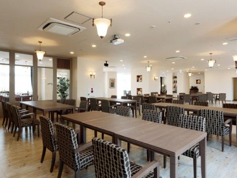 上質な椅子とテーブルが用意された開放的なレストランである。壁や天井には、オシャレな照明が設置されている。