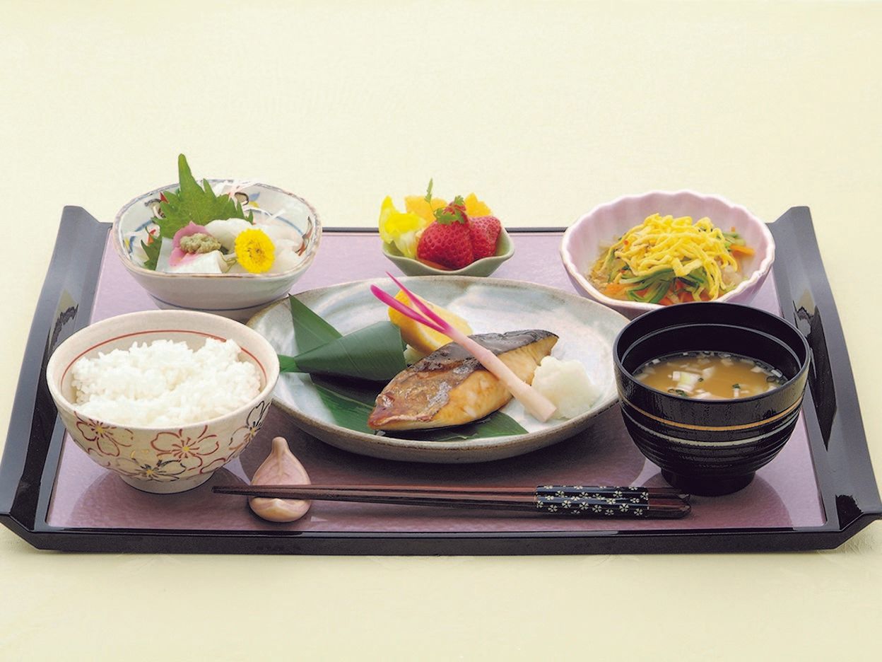 陶器の器におかずやフルーツがきれいに盛り付けられている、お膳一式