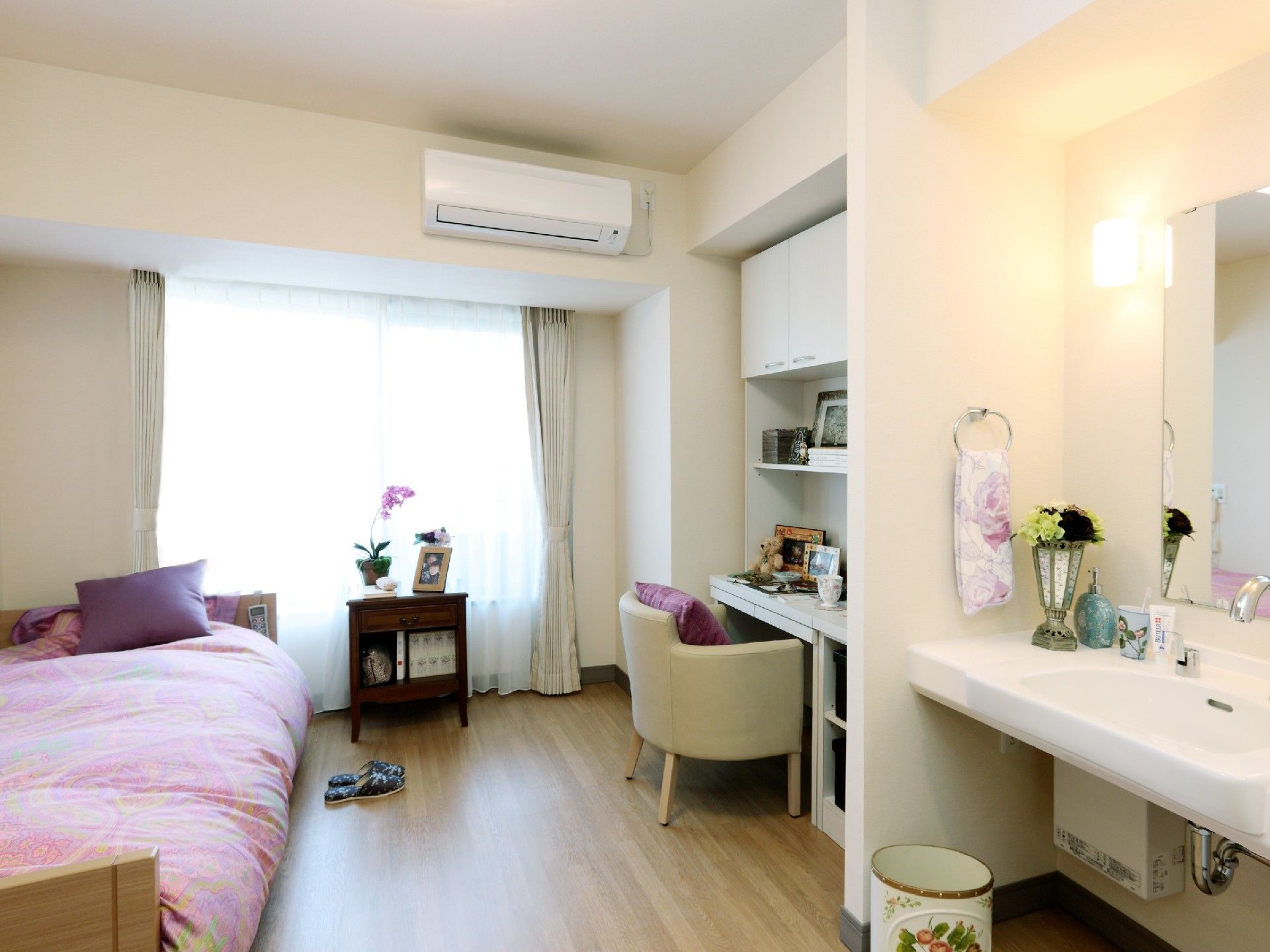 部屋には、机やベッド、エアコンなど生活に必要な設備が整えられている。居室外には、バルコニーが設けられている。