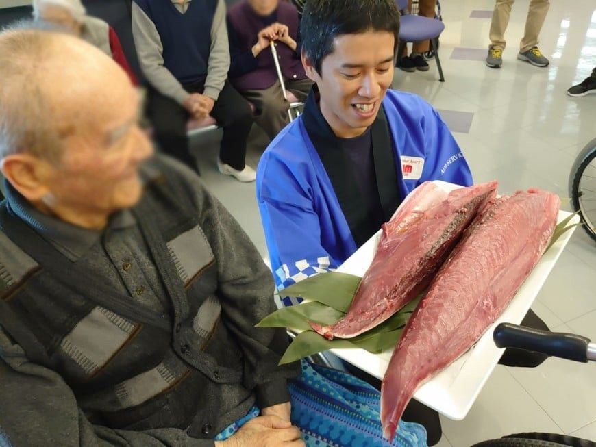 魚を持つ男性と高齢者