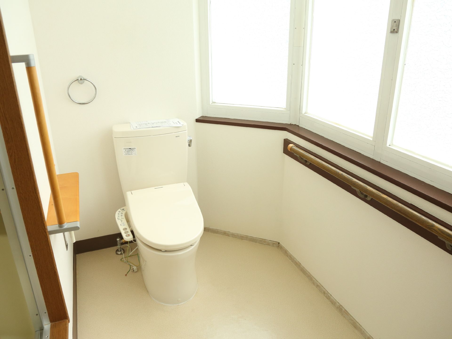 大きな窓からたくさんの光が入り、とても明るいトイレである。手すりが必要な部分についており、安全面にも配慮されている。