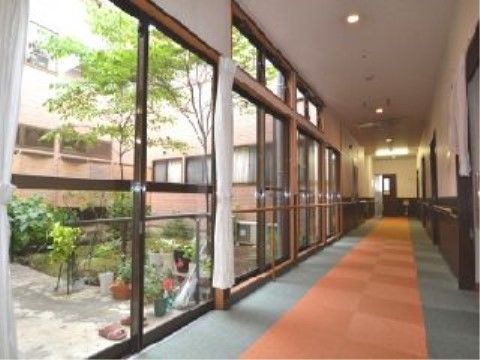 「スマイリングホーム メディス川越」一面ガラス張りの廊下からは中庭がご覧いただけます。閉鎖感を感じること無く開放的な生活を送っていただけます。