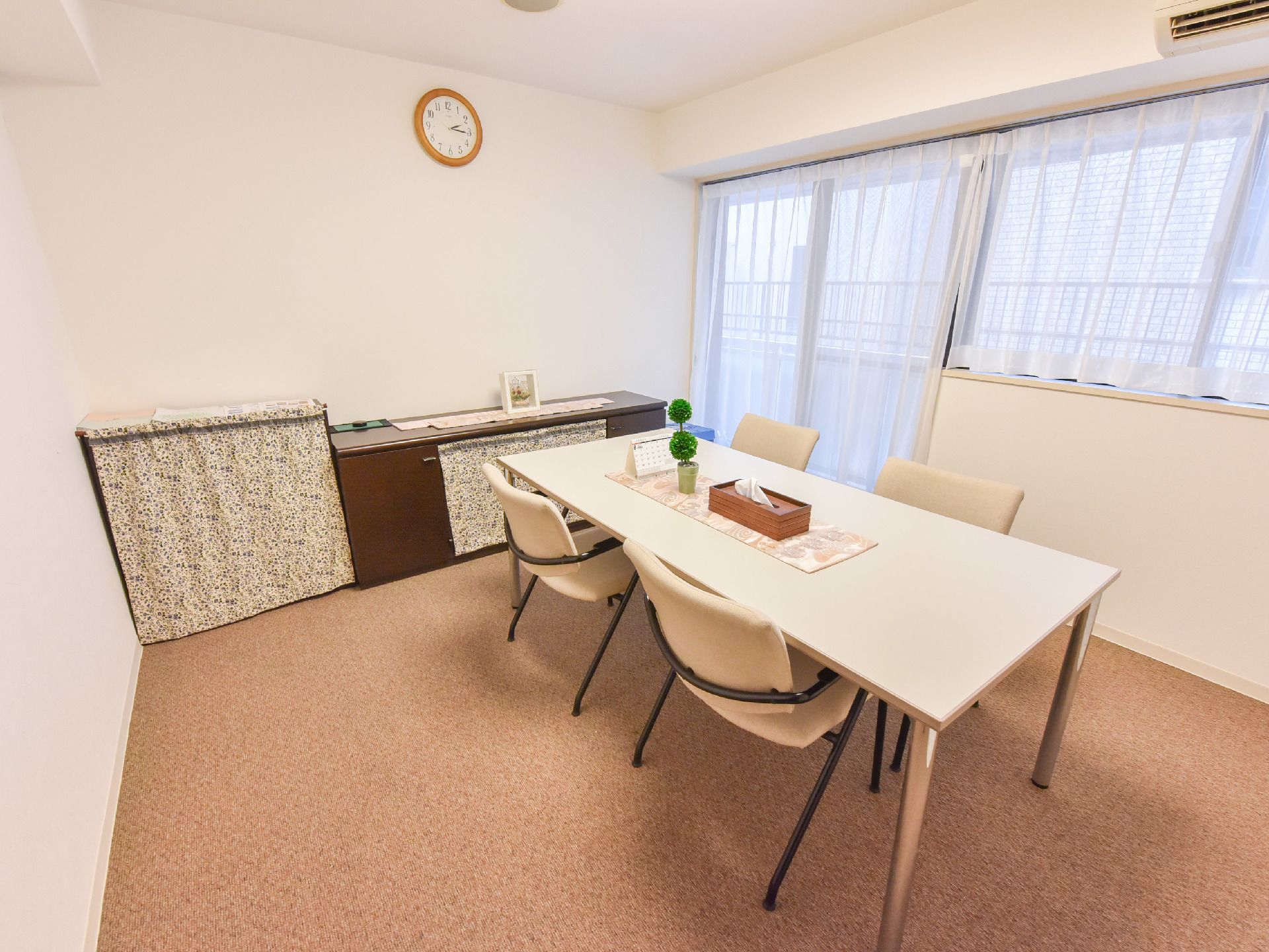 談話室は個室に。大きな窓があり、テーブルと棚が用意されてある、とてもシンプルな部屋。卓上にはカレンダーなどが置いてある。
