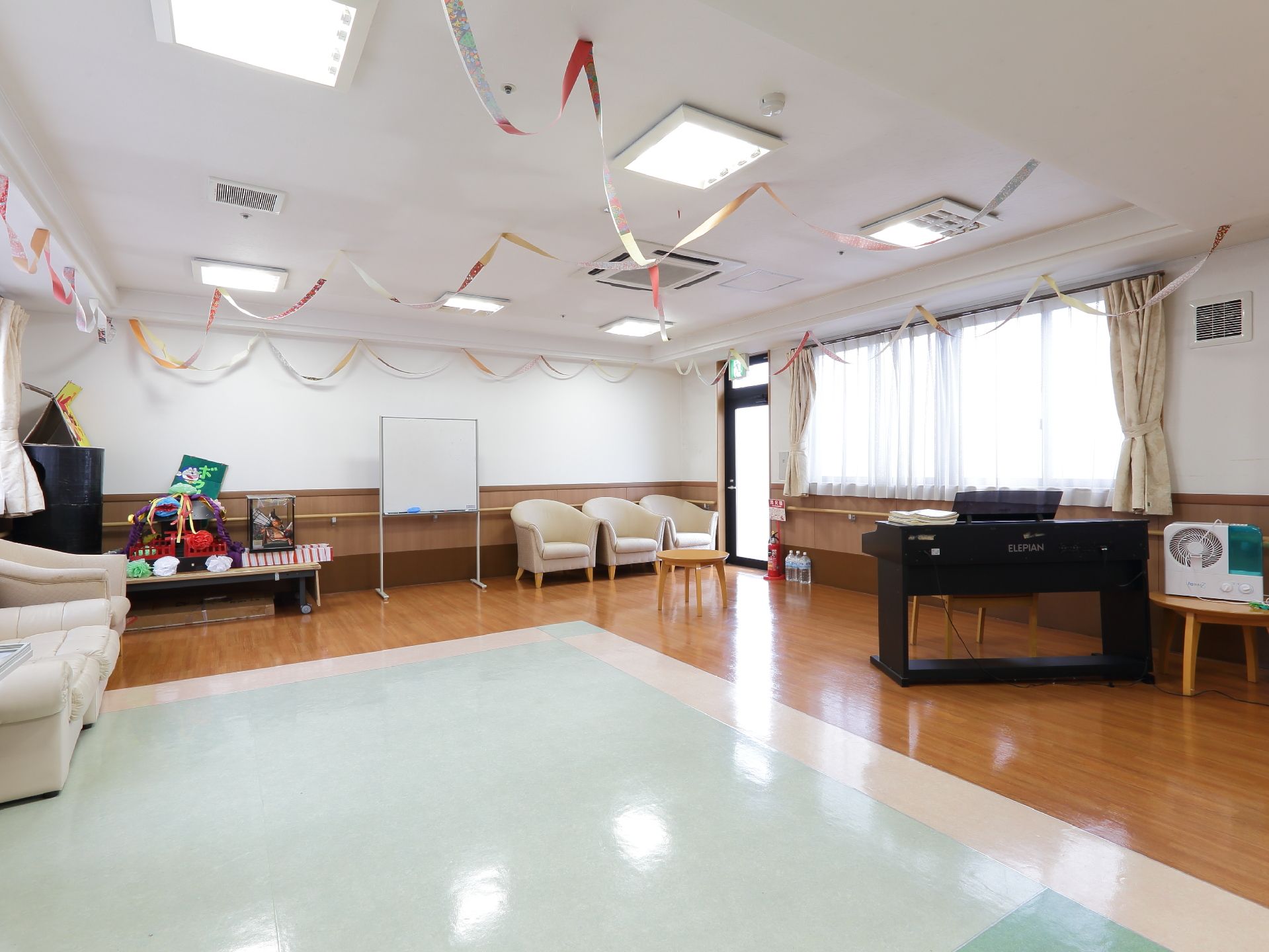 室内には椅子が壁際に置かれている。その他電子ピアノやソファも設けられている。様々に利用できる一室である。