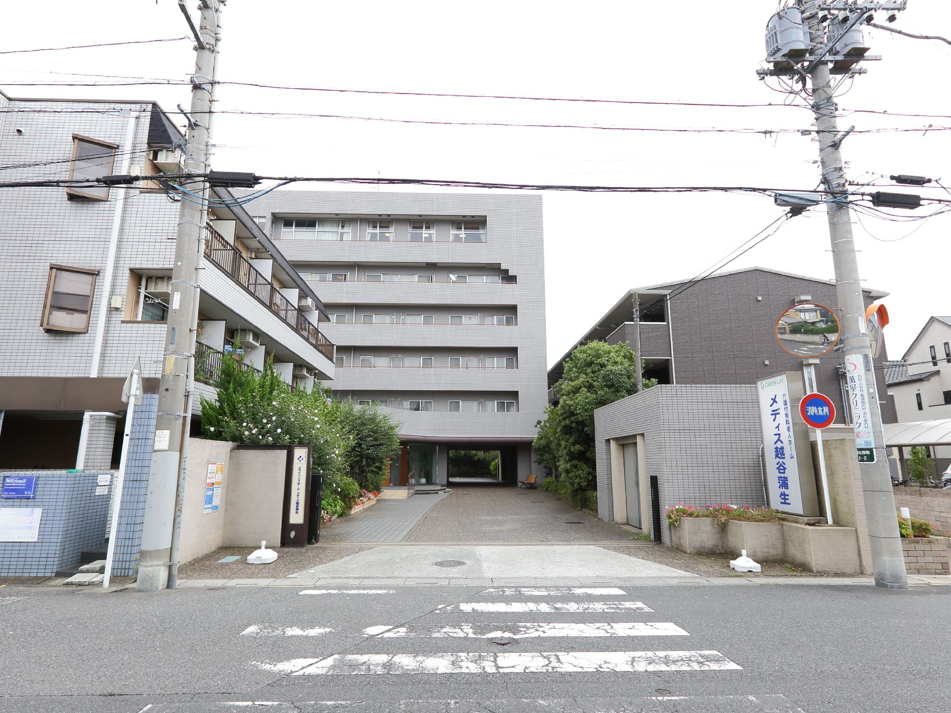 グレー色の外観の施設は目の前が横断歩道になっている。車で敷地内に入ることのできるようなスペースがある。