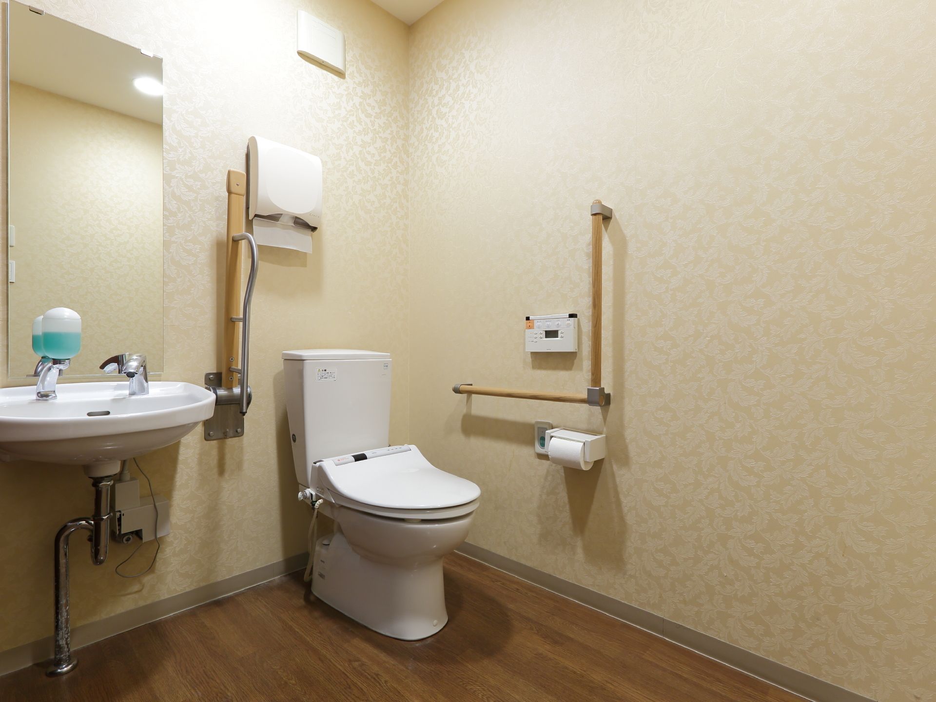 一般家庭にあるのと変わらないトイレが設置されている。室内に鏡があり、手すりと緊急用のブザーも用意されている。