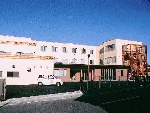 「スマイリングホーム メディス深谷」ピンクが印象的な三階建ての施設外観です。