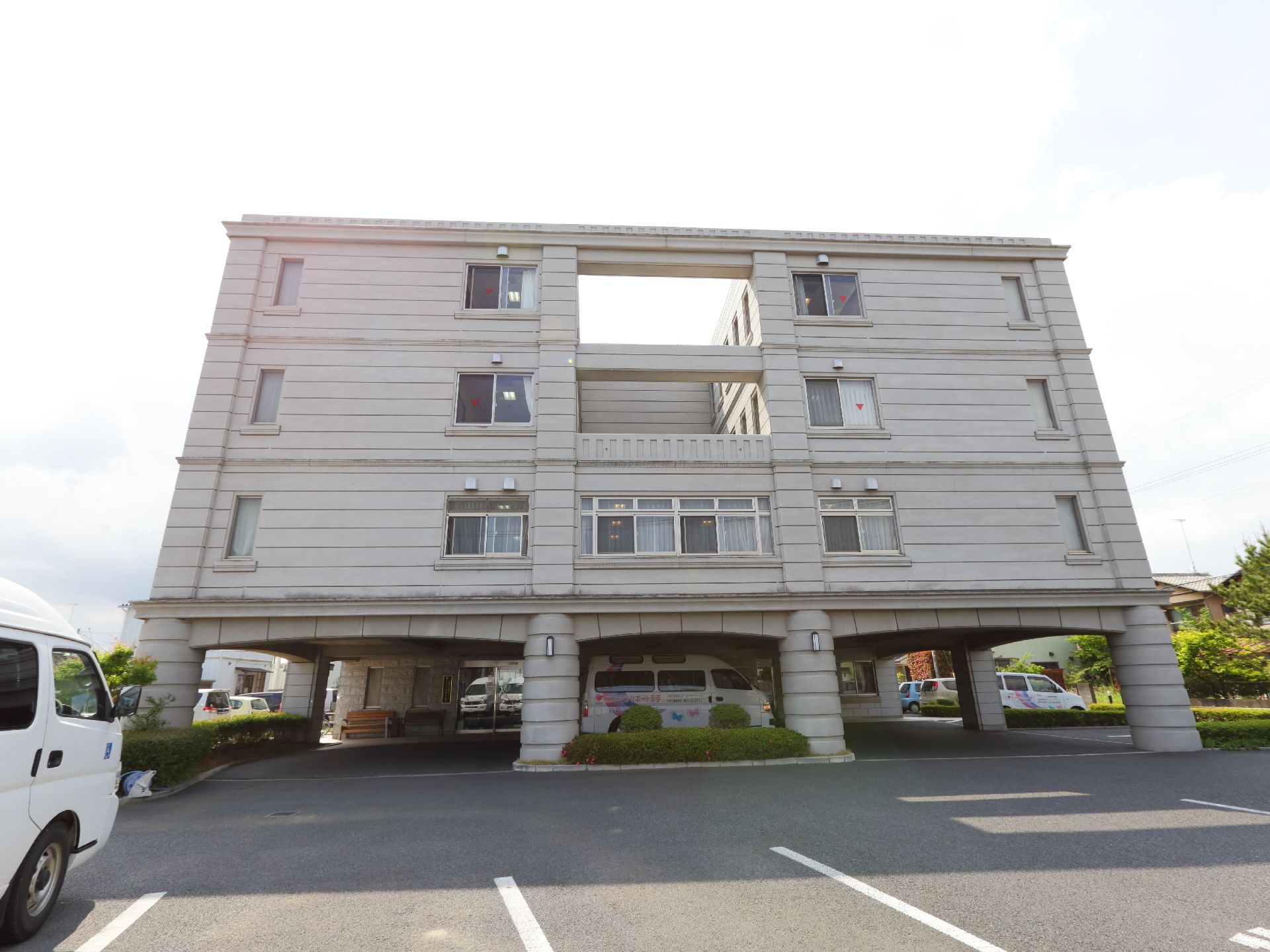建物の一階部分がルーフ状になっている、四階建ての施設外観