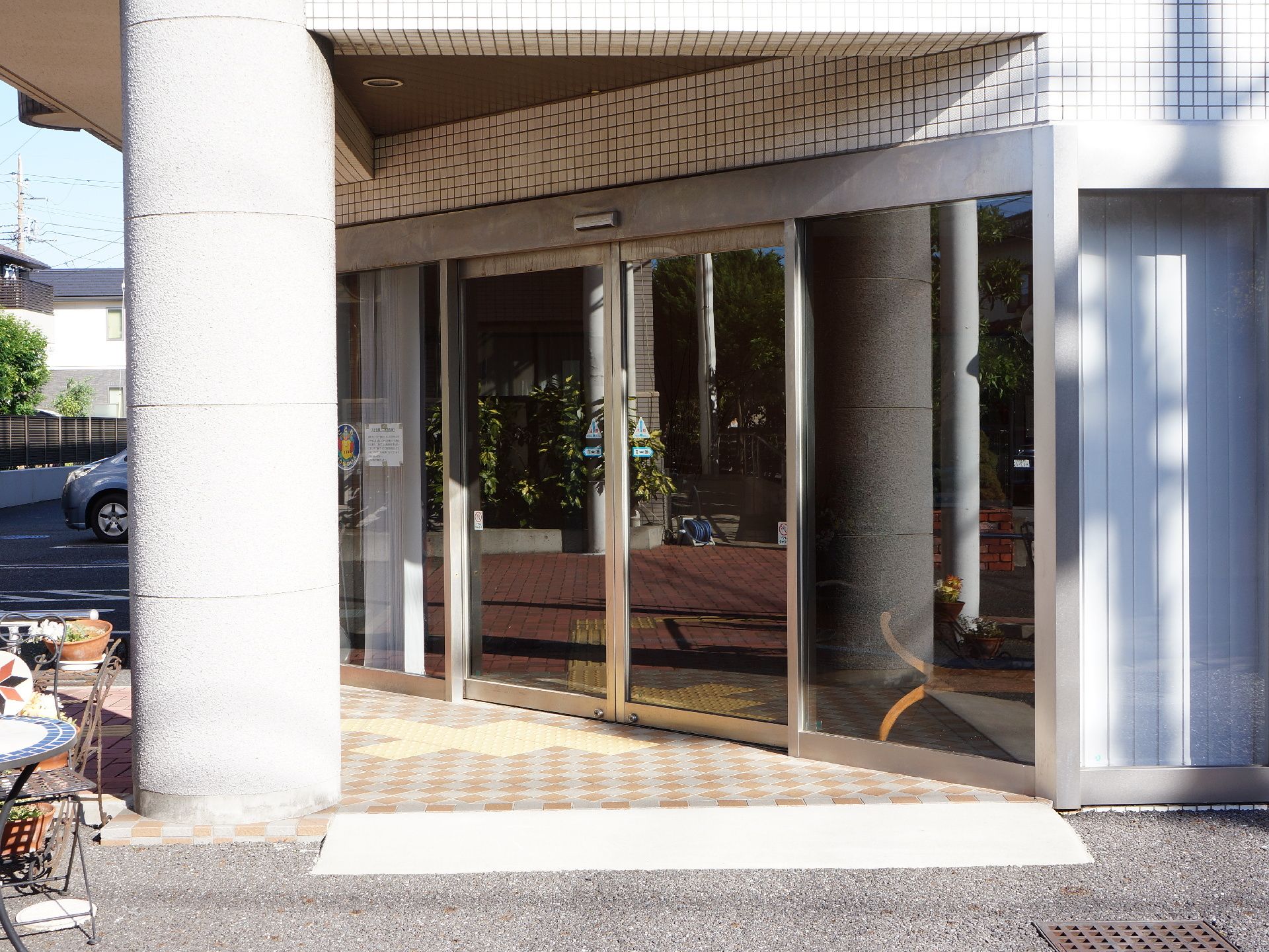 施設入り口の自動ドアは反射する大きなガラス。ドア手前にはスロープがあるが、低めなので車いすでも歩行でも通りやすい。
