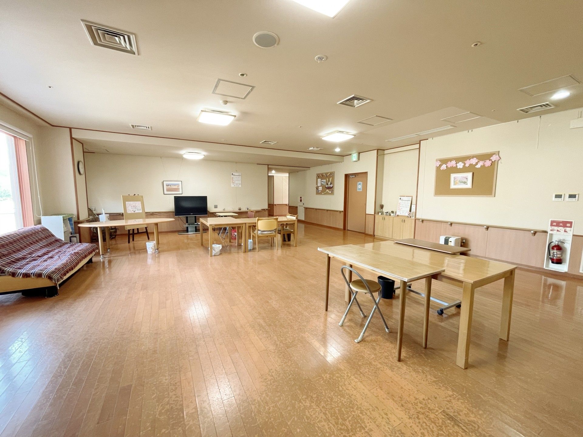 木製のダイニングテーブルセットが複数置かれた共有スペースには木材がふんだんに使用されている。