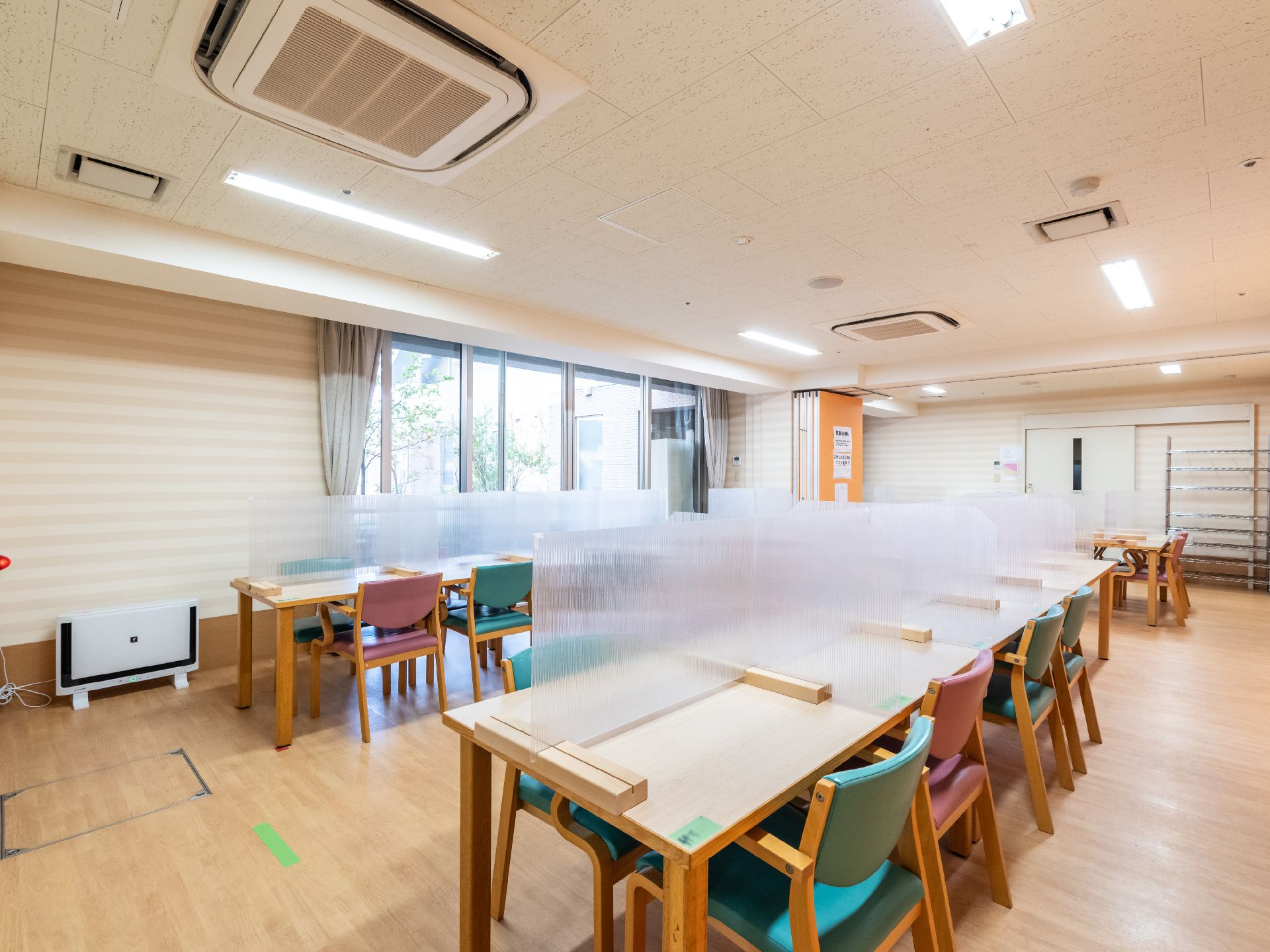 椅子と仕切り板がついているテーブルが設置された共有スペース