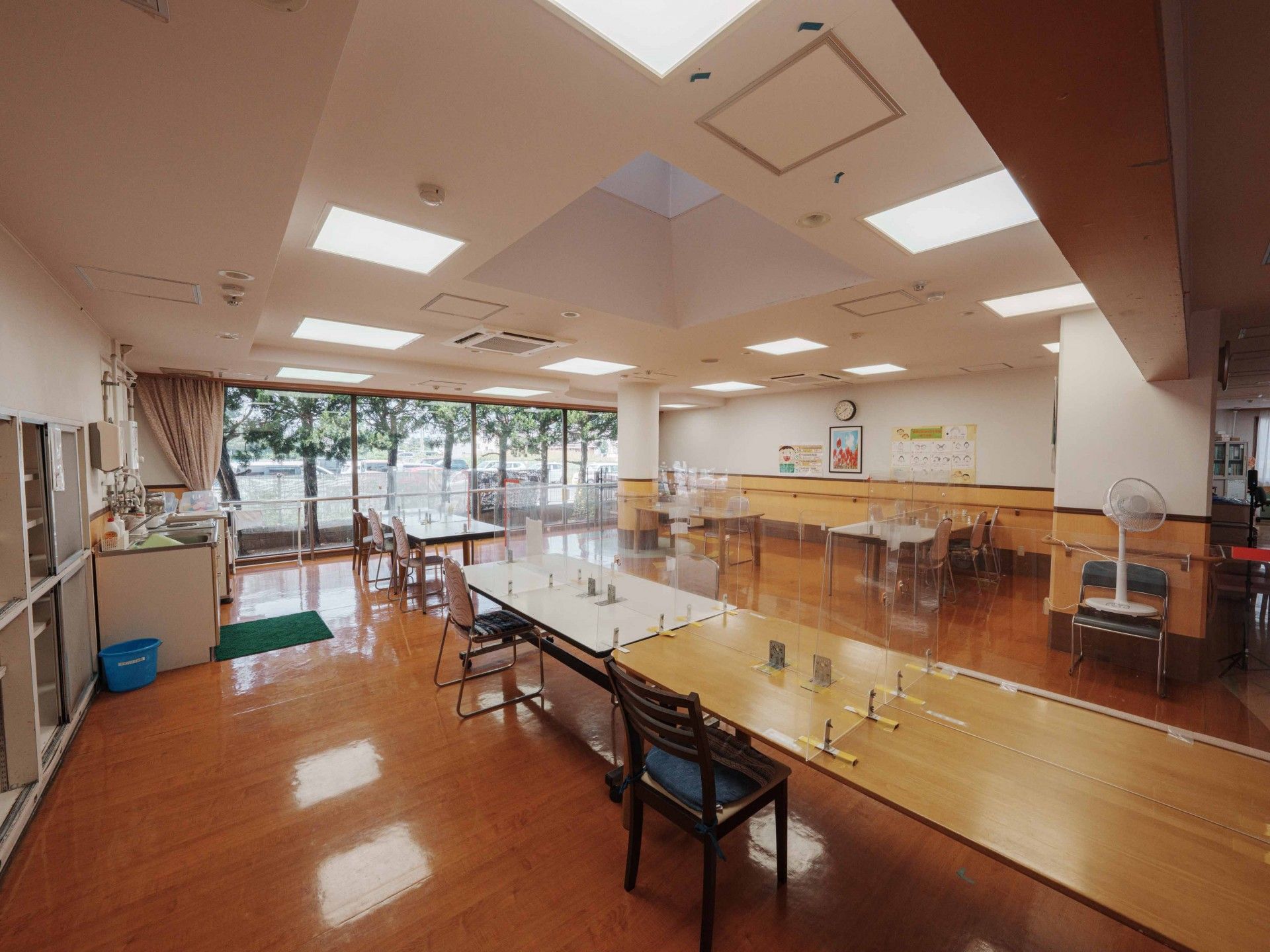 赤いトレーニング器具を引っ張りリハビリをする高齢女性と理学療法士の男性