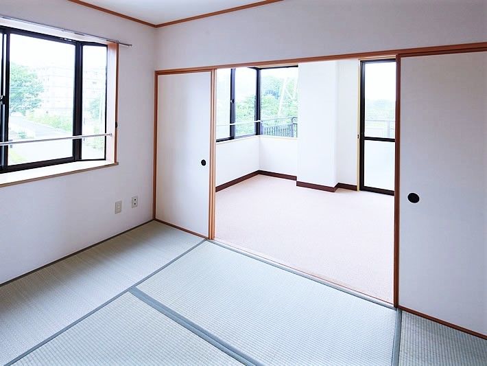 緑の畳が敷かれた和室と洋室がある部屋には大きな窓があり、カーテンや家具はまだない。