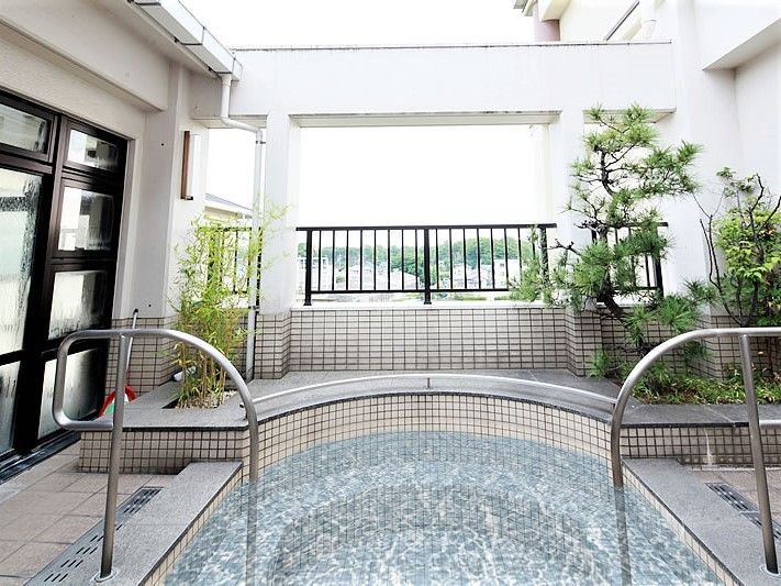 緑が植えられた展望風呂。タイル張りの浴槽には両サイドに手すりが付いている。