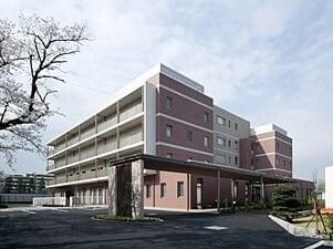 ブラウンと白の５階建ての建物の周りには庭もあり、各フロアにベランダも付いている。