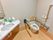 広々としたトイレスペースには、便器横に三角型の洗面台を設置している。便座の両側に手すりを完備している。