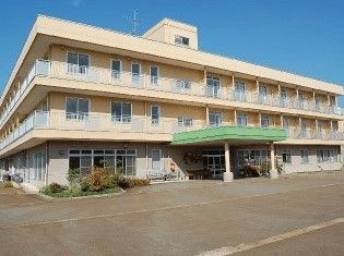 3階建てのオレンジ系の建物。建物のある敷地は広く、ベランダも付いている。