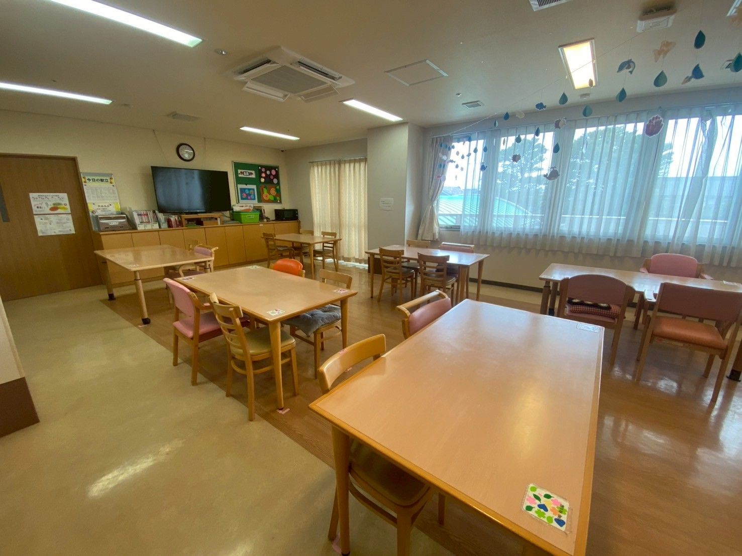 介護車両の前にいる車椅子に乗った高齢の男女と介助をするヘルパー