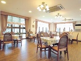 小さなフレンチレストランのような雰囲気の食堂。大きな窓がたくさん付き日当たり良好。テーブルクロスがセットされている。