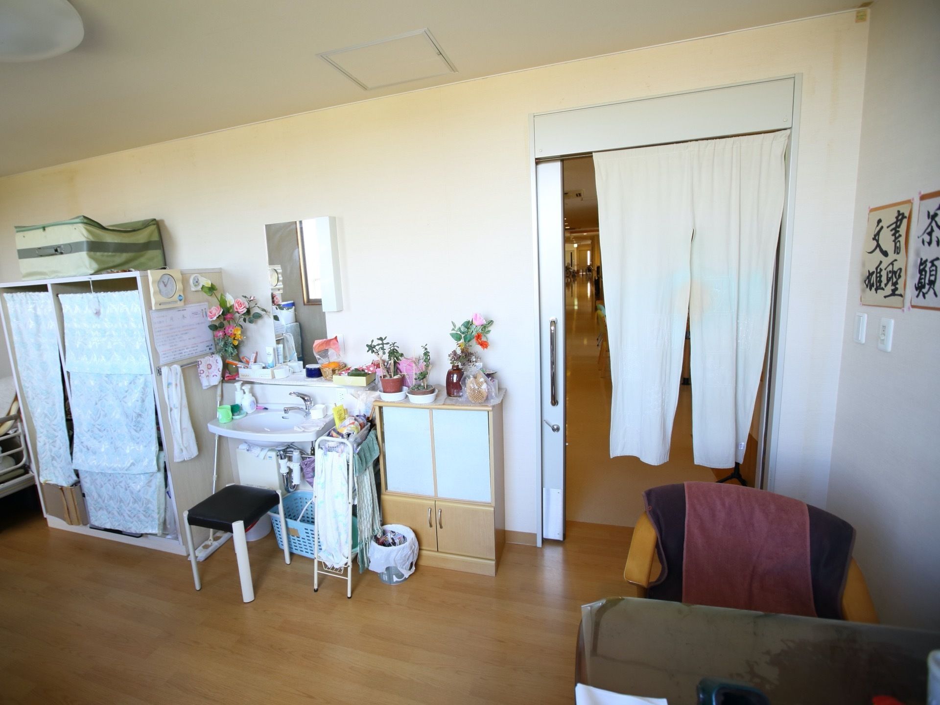 居室の入口は引き戸になっていて、開けたままでもよいように、暖簾をかけている。居室内には洗面台がある。