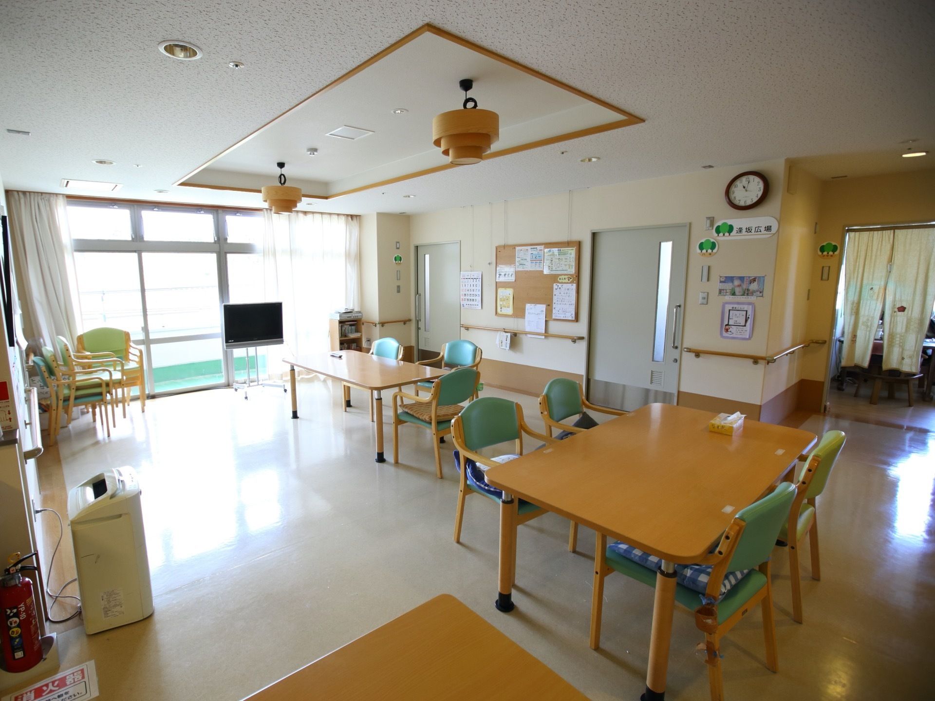 大きな窓のある明るい共有スペースにはテーブルが複数置いてある。食事やイベントで利用することができる。