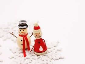 雪だるまとサンタクロースが寄り添い、雪の結晶の上でポーズしているショット。