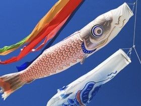 青空高く舞い上がり、威勢よく泳ぐ赤と青の鯉のぼりと吹き流し。