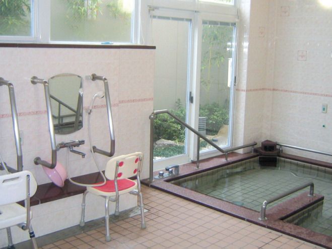 白を基調とした建物は横に長く各フロアにベランダがあり、車寄せが設置され、敷地内には庭もある。
