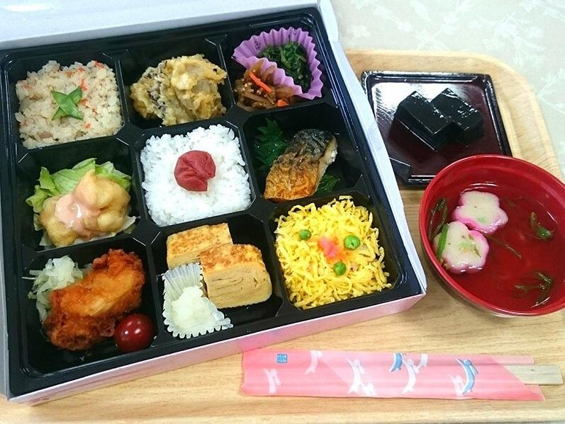 唐揚げやサバの塩焼き、ちらし寿司、卵焼き、炊き込みご飯など、９種類の料理が詰められている弁当。