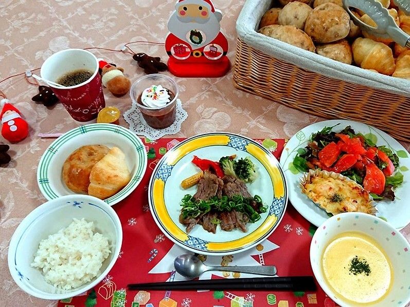 スープにステーキ、スモークサーモンのサラダにグラタン、白いご飯とパン、チョコレートデザートがある。