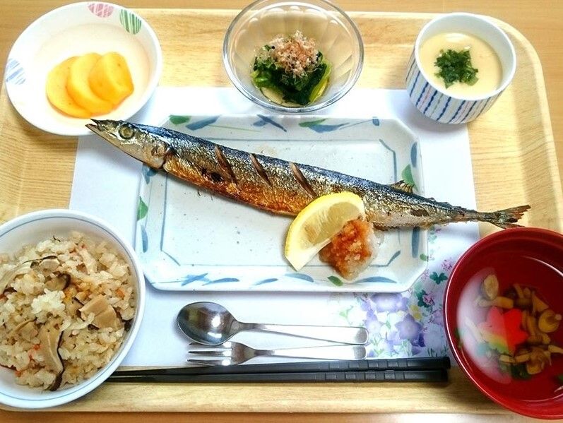 メインはサンマの塩焼き。沢庵や吸い物、炊き込みご飯、青菜のお浸し、茶碗蒸しなどが並んでいる。