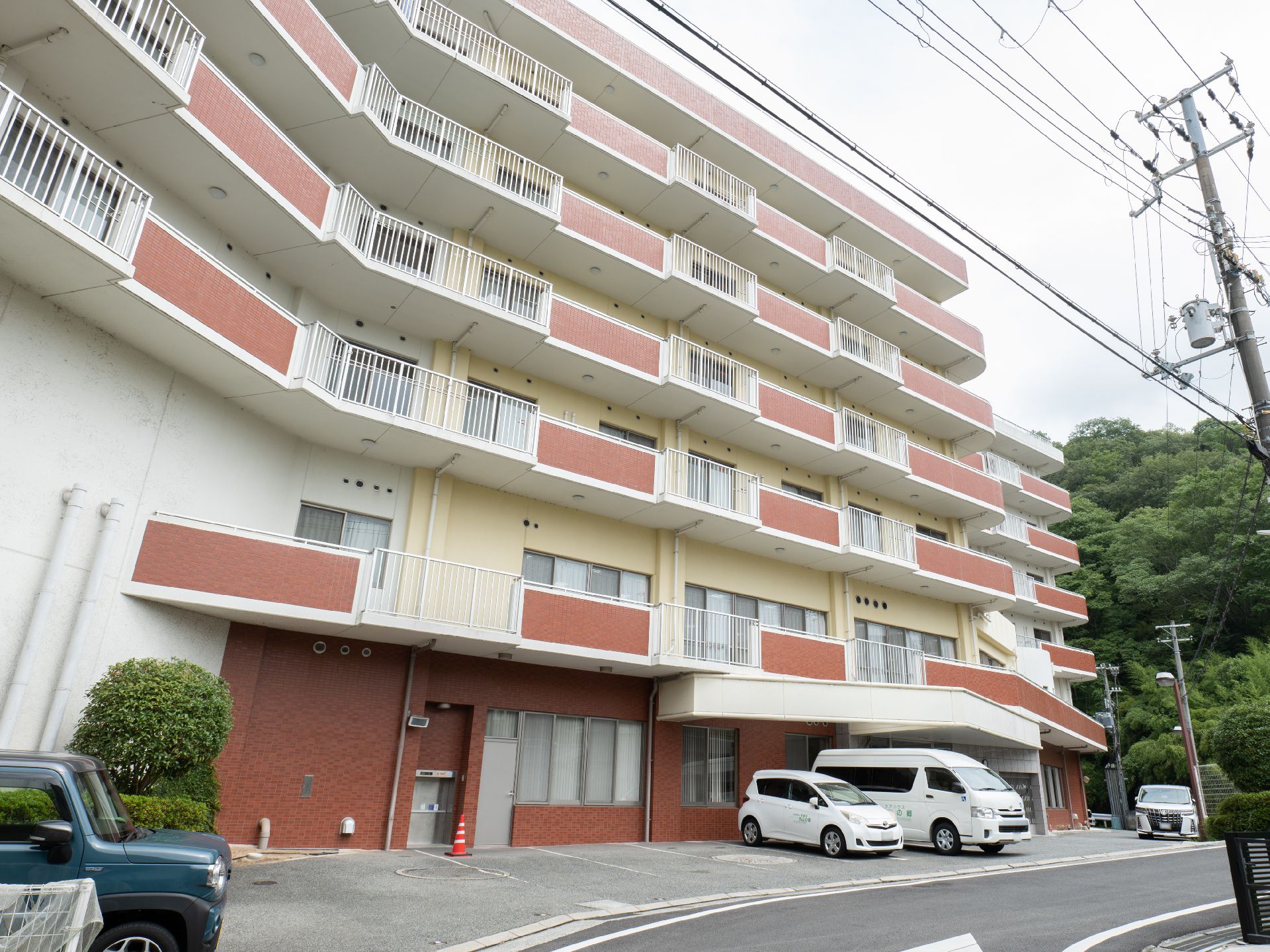 広い駐車場が隣接している、おしゃれな屋根のある介護施設